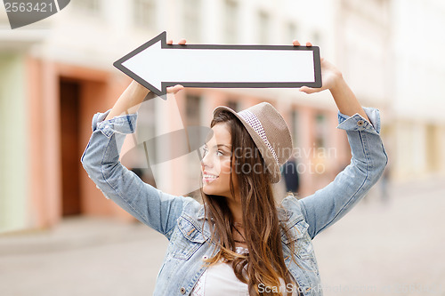 Image of girl showing direction with arrow in the city