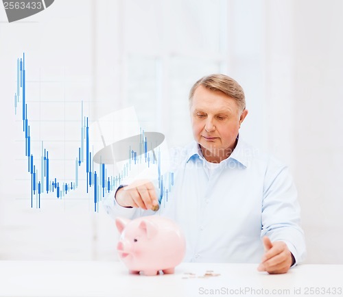 Image of old man putting coin into big piggy bank