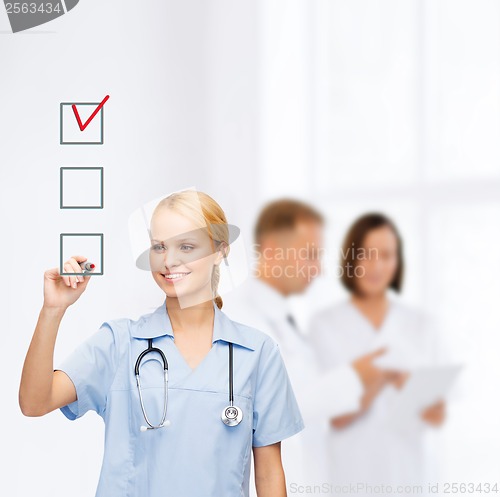 Image of doctor or nurse drawing checkmark into checkbox