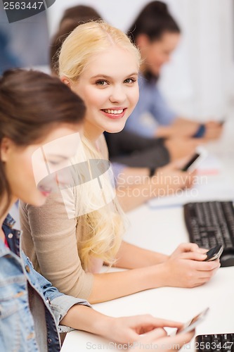 Image of students with computer monitor and smartphones