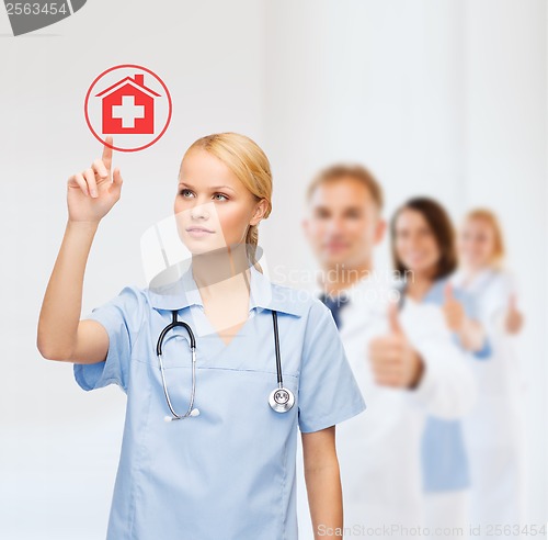 Image of smiling doctor or nurse pointing to hospital icon