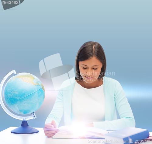 Image of teacher with globe and book at school