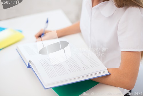 Image of student girl writing in notebook at school