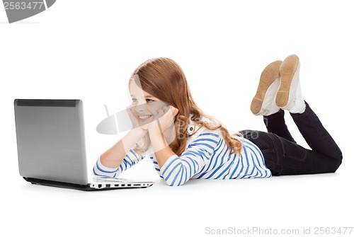 Image of smiling student girl with laptop computer lying