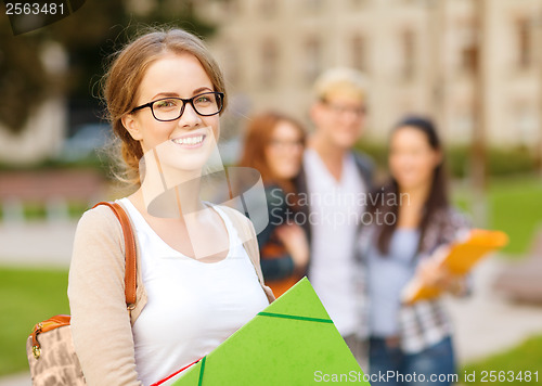 Image of female student in eyglasses with folders