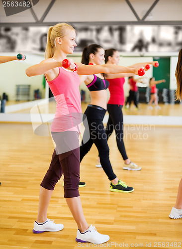 Image of group of smiling people working out with dumbbells