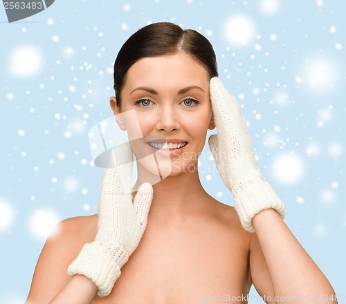 Image of smiling young woman in white mittens