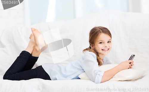 Image of smiling girl with smartphone at home