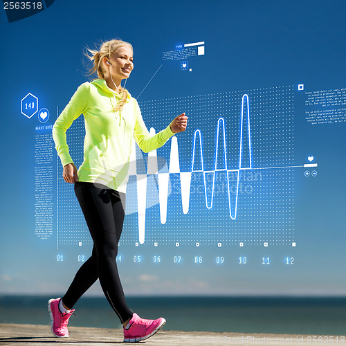 Image of smiling woman doing sports outdoors with earphones