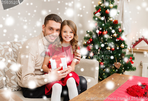 Image of smiling father and daughter holding gift box