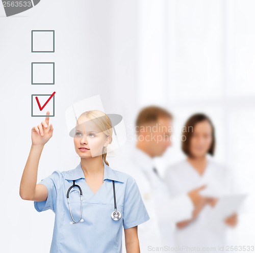 Image of smiling doctor or nurse pointing to checkmark