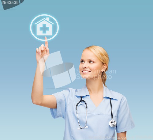 Image of smiling doctor or nurse pointing to hospital icon