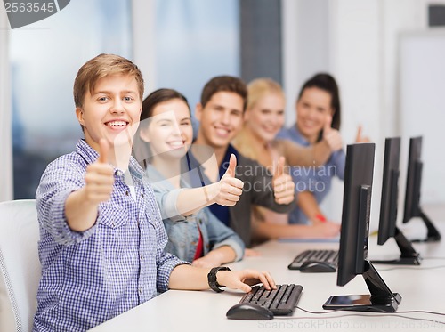 Image of students with computer monitor showing thumbs up