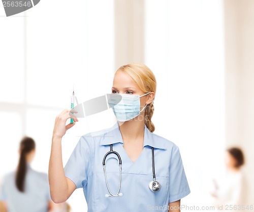 Image of female doctor or nurse in mask holding syringe