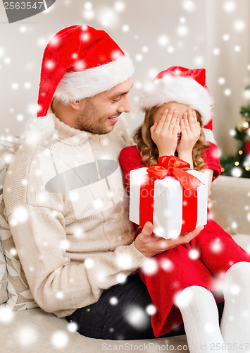 Image of smiling daughter waiting for a present from father