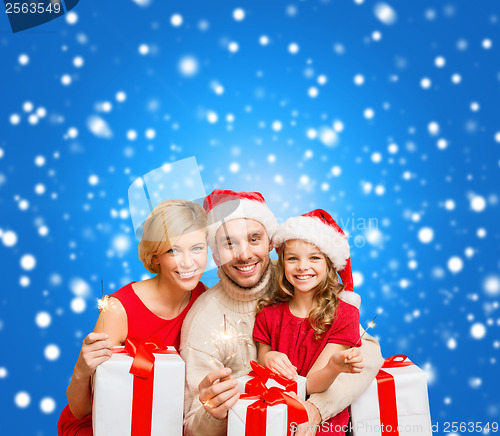 Image of smiling family holding gift boxes and sparkles