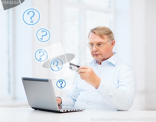 Image of old man with laptop and credit card at home