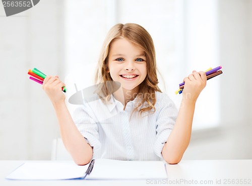 Image of smiling girl showing colorful felt-tip pens