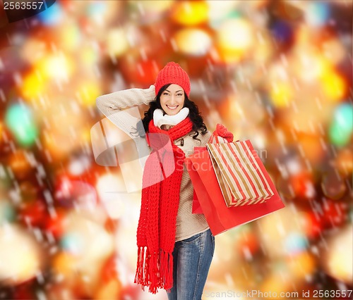 Image of smiling woman in warm clothers with shopping bags