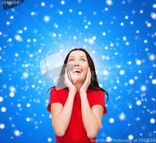 Image of amazed laughing young woman in red dress