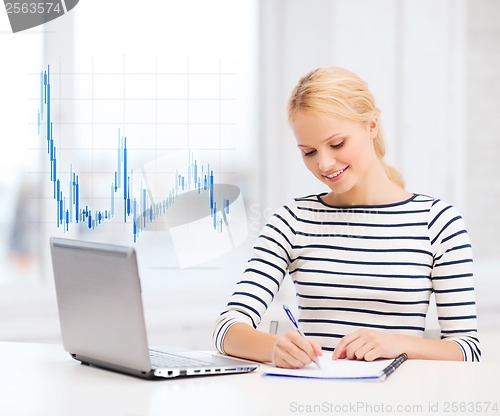 Image of smiling student with laptop computer and documents