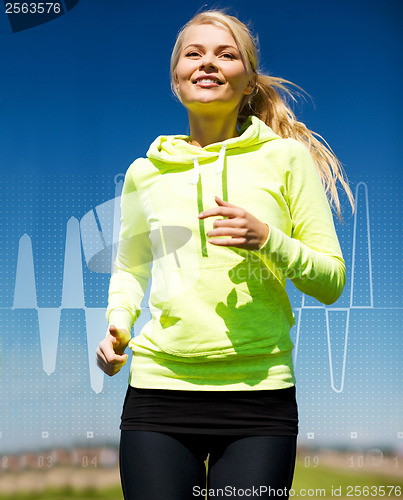 Image of smiling woman jogging outdoors