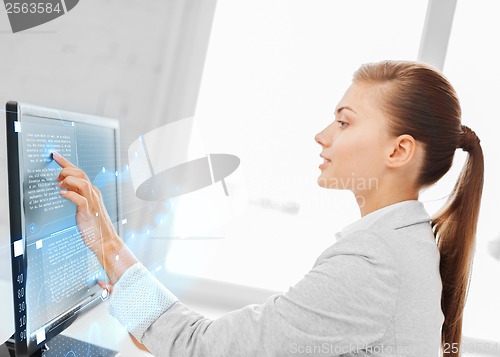 Image of smiling businesswoman with touchscreen in office