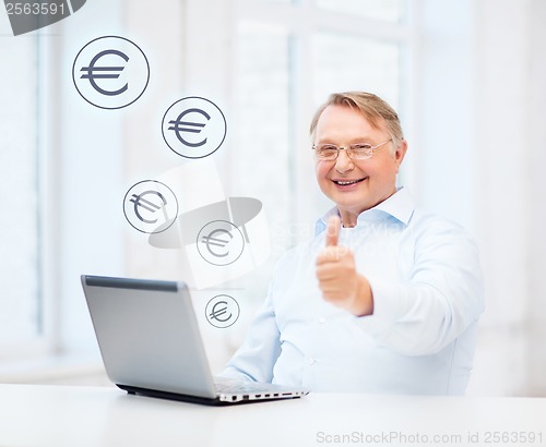 Image of old man with laptop computer showing thumbs up