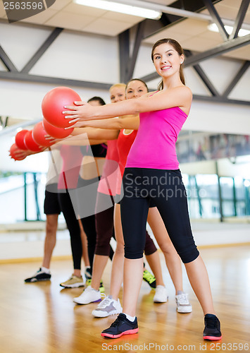 Image of group of smiling people working out with ball