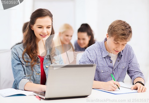 Image of students with laptop and notebooks at school