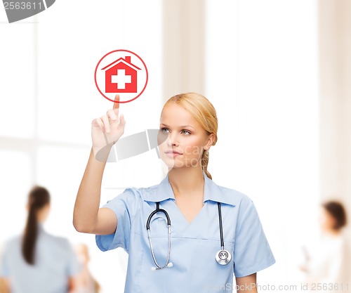 Image of smiling doctor or nurse pointing to hospital icon