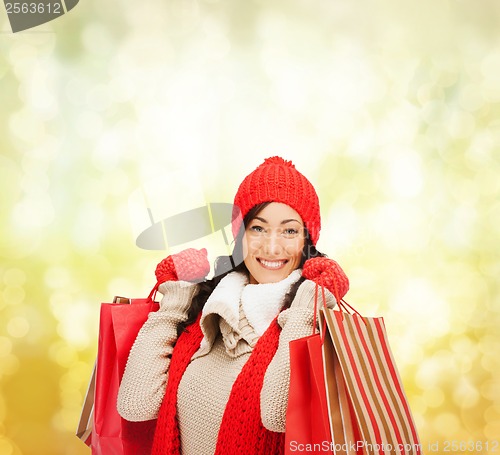 Image of smiling woman in warm clothers with shopping bags