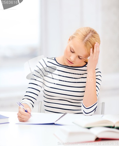 Image of concentrated woman studying in college
