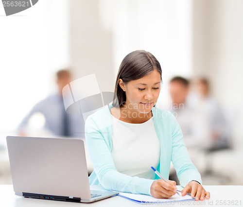 Image of asian businesswoman with laptop and documents