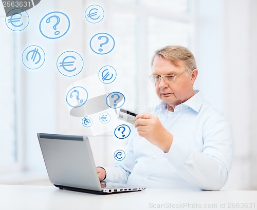 Image of old man with laptop and credit card at home