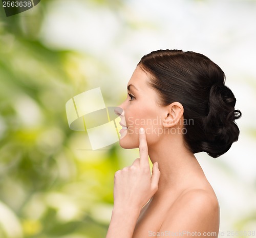 Image of smiling young woman pointing to her cheek