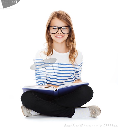 Image of smiling little student girl sitting on the floor