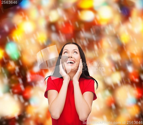 Image of amazed laughing young woman in red dress