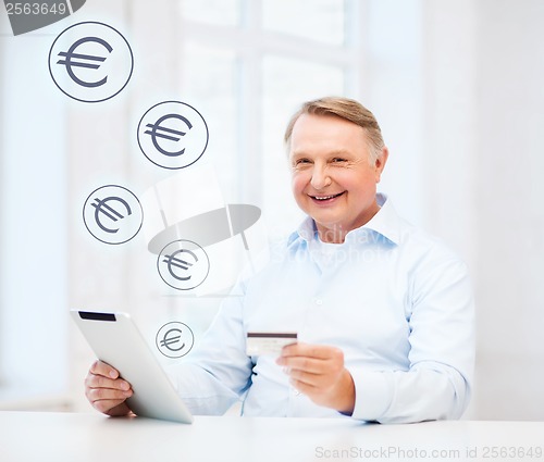 Image of old man with tablet pc and credit card at home