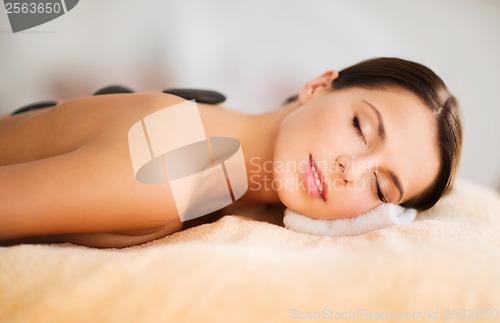 Image of beautiful woman in spa salon with hot stones