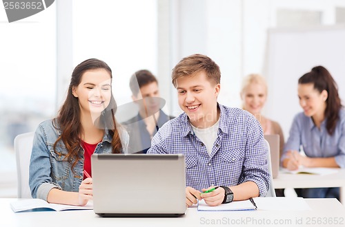 Image of students with laptop and notebooks at school