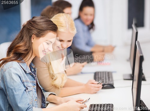 Image of students with computer monitor and smartphones