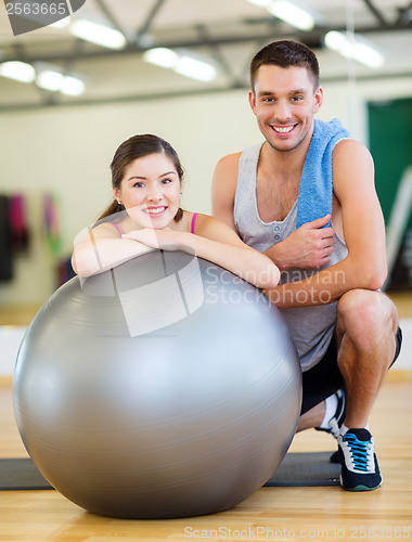 Image of two smiling people with fitness ball