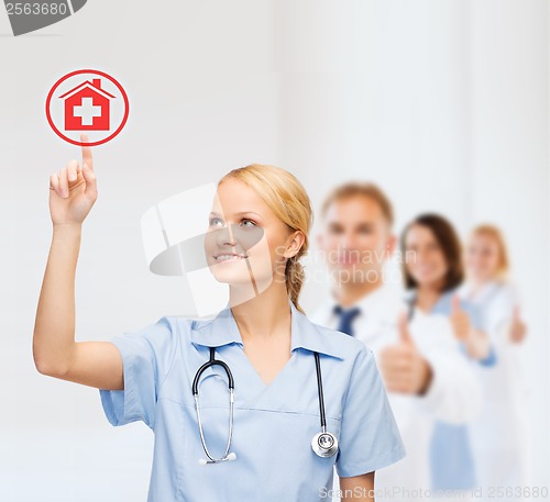 Image of smiling doctor or nurse pointing to hospital icon