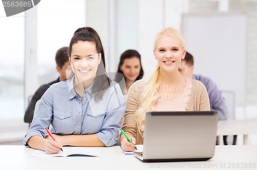 Image of students with laptop and notebooks at school