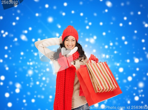 Image of smiling woman in warm clothers with shopping bags