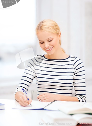 Image of smiling woman studying in college