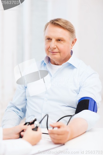 Image of female doctor or nurse measuring blood pressure