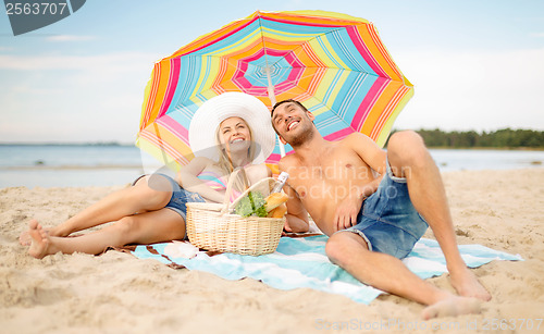 Image of smiling couple sunbathing on the beach