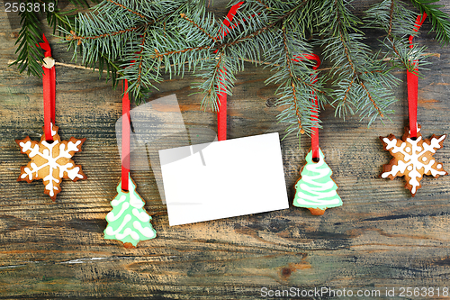 Image of Card and Christmas cookies on fir branches.